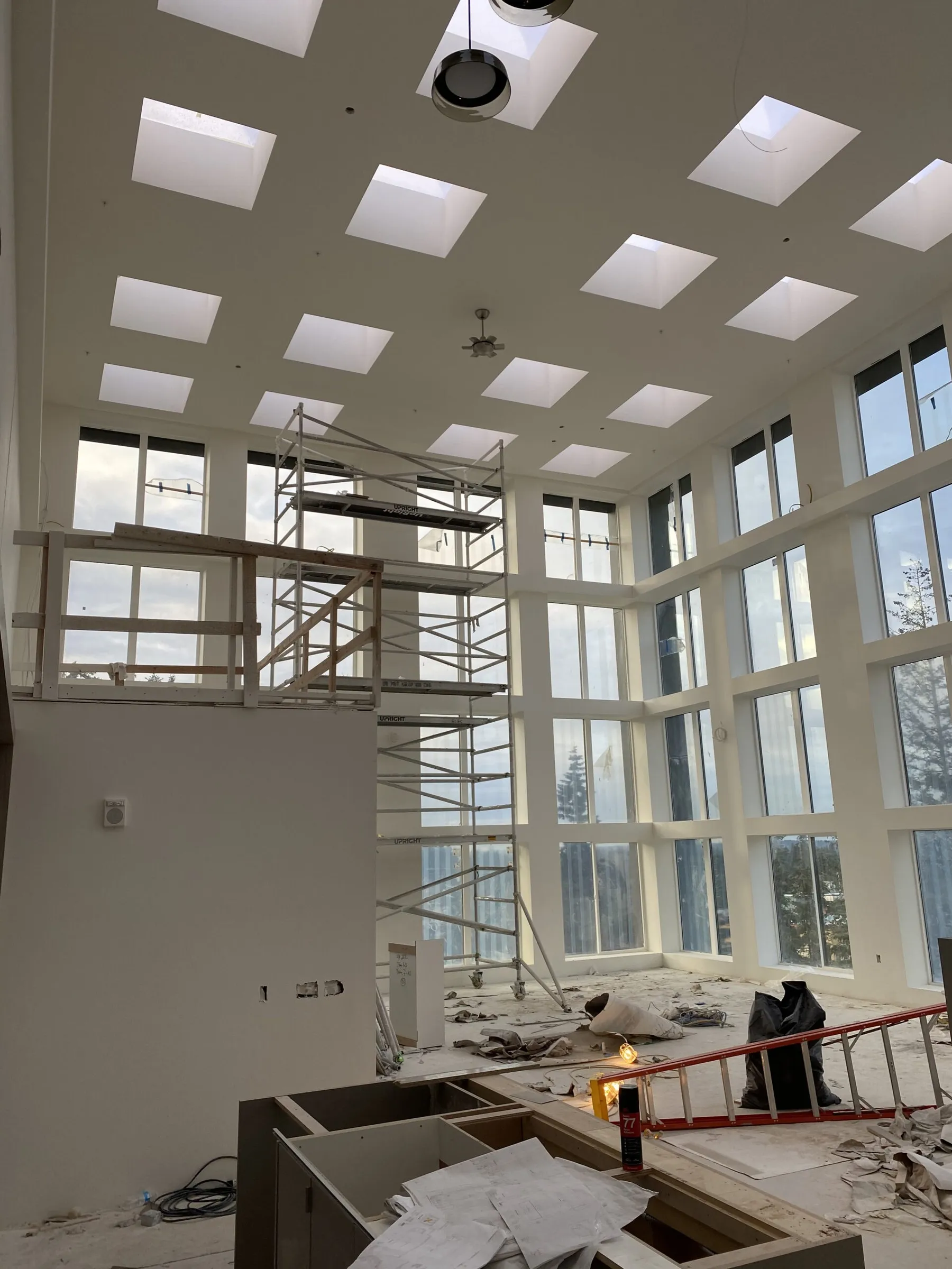 Double-height room at Esterra Park with a coffered skylight ceiling and scaffolding