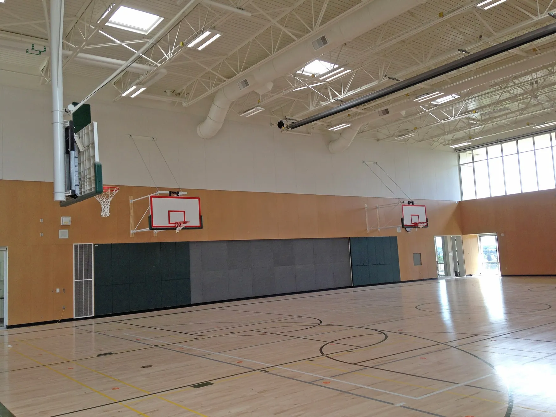 Renovated Magnolia school gymnasium with wood floor and basketball hoops