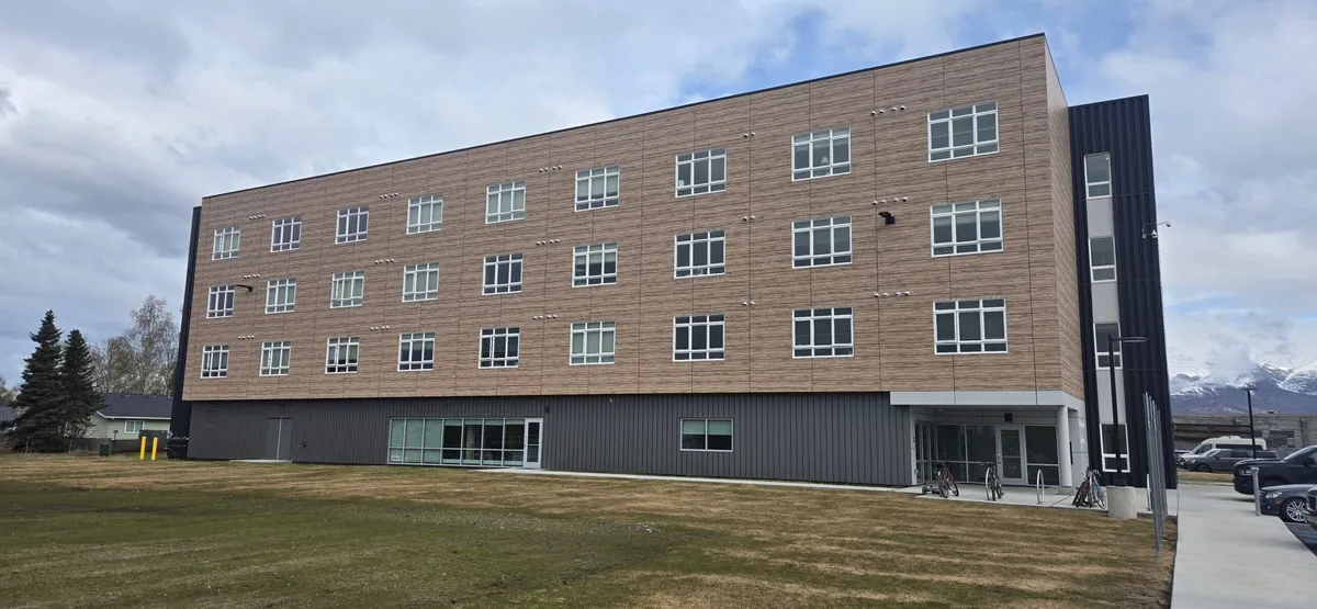Providence Housing building corner with dark metal and tan siding