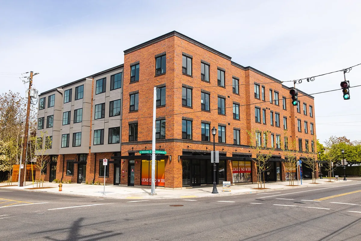 Koz on Killingsworth four-story brick mixed-use building on a Portland street corner
